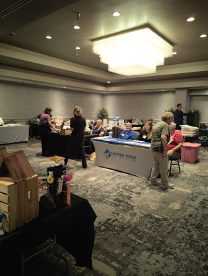 Several convention attendees interacting with vendors at their booths.